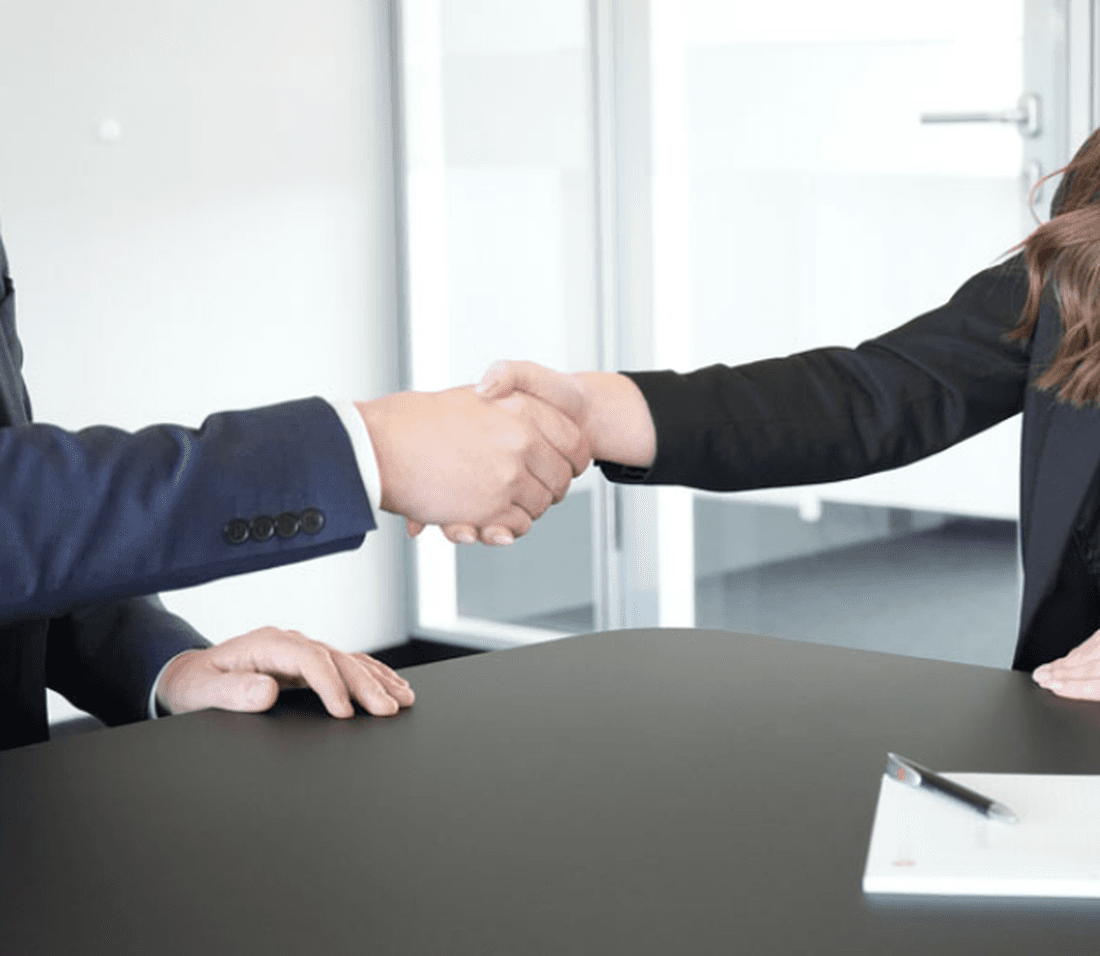 Handshake Mann und Frau in Business Outfits