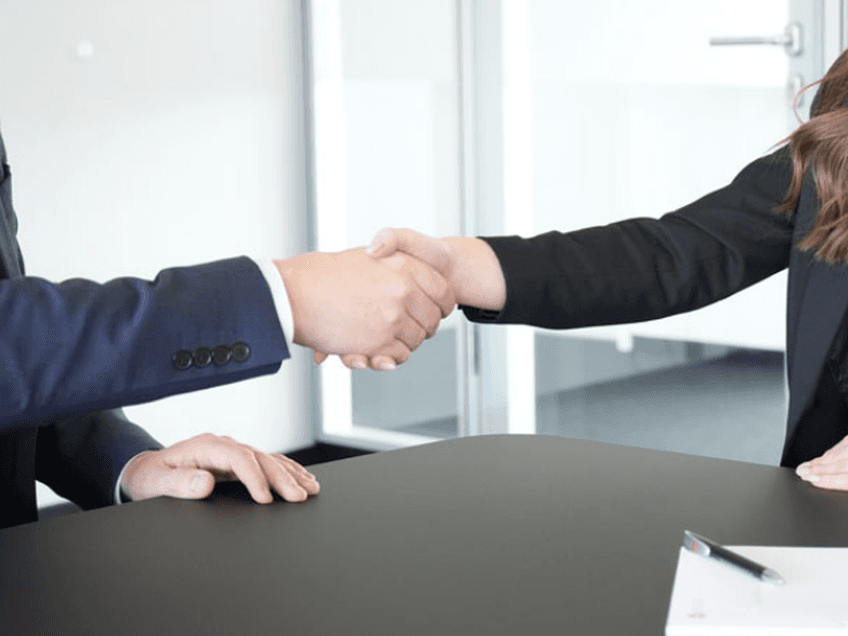 Handshake Mann und Frau in Business Outfits